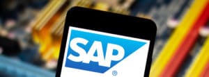 SAP company logo on a white screen phone with an unfocused background of a motherboard