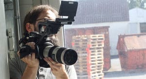 A cameraman filming with a big professional camera